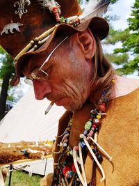 Close-up of mature man wearing traditional clothing while smoking cigarette outdoors