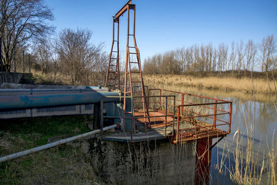 Metallic structure on field against clear sky