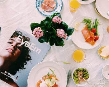 Directly above shot of food on table by flower vase and magazine