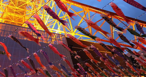 Low angle view of multi colored umbrellas hanging against sky