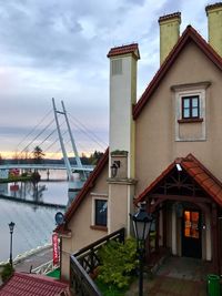 Houses by river against sky in city