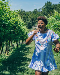 Smiling woman walking at vineyard