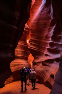 Rear view of people walking on rock