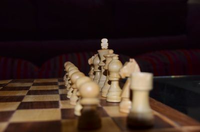 Premium Photo  Closeup of chess pieces on the chessboard under the lights  with a blurry background