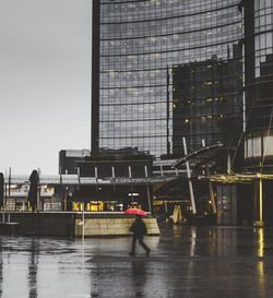 Rear view of man walking by building in city