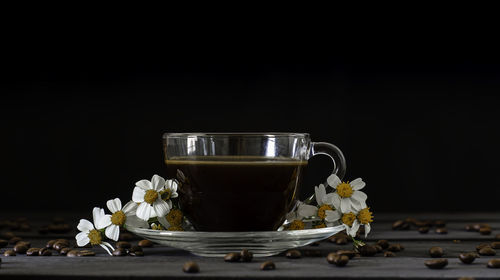 Close-up of coffee cup on table against black background