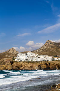 Scenic view of sea and mountains against blue sky