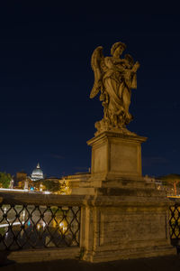 Statue in city at night