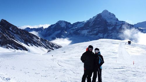 Man standing on snow covered mountain against sky