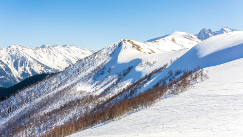 Scenic view of snowcapped mountains against clear blue sky