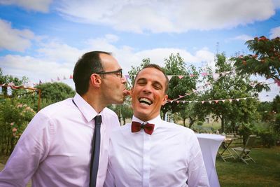 Happy friends smiling while standing against plants