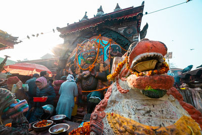Statue outside temple against building and sky
