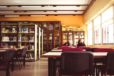 Rear view of woman sitting on table in building