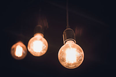 Low angle view of illuminated light bulbs