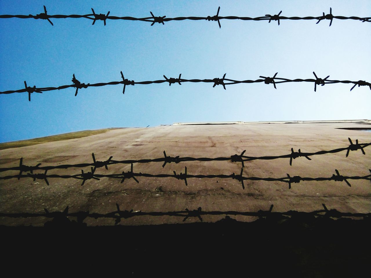 CLOSE-UP OF FENCE AGAINST CLEAR SKY