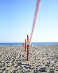 Lifeguard hut on beach against clear blue sky