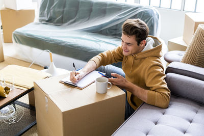 Woman sitting on sofa at home