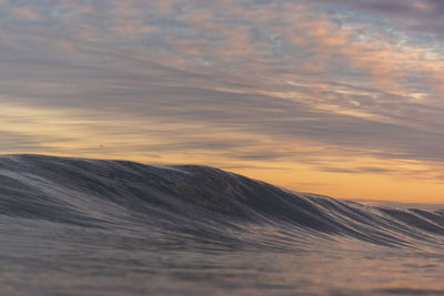 Scenic view of wave against sky during sunrise