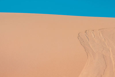 Sand dunes in desert against clear sky