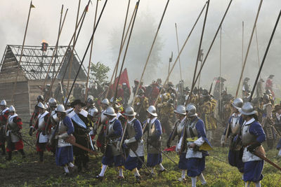 People in costume walking on field against sky