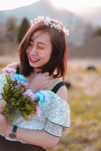 Portrait of a smiling young woman holding flower