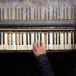 Close-up person hand playing piano