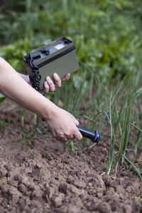 Cropped hands of woman using agricultural machinery on field