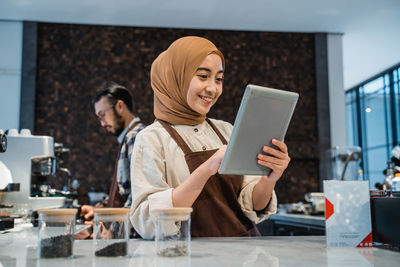 Smiling woman using digital tablet at cafe