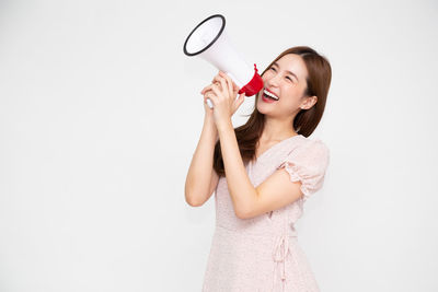 Young woman smiling against white background
