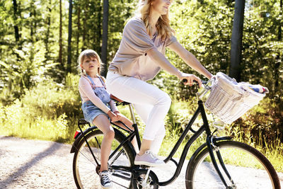 Mother riding bicycle with daughter