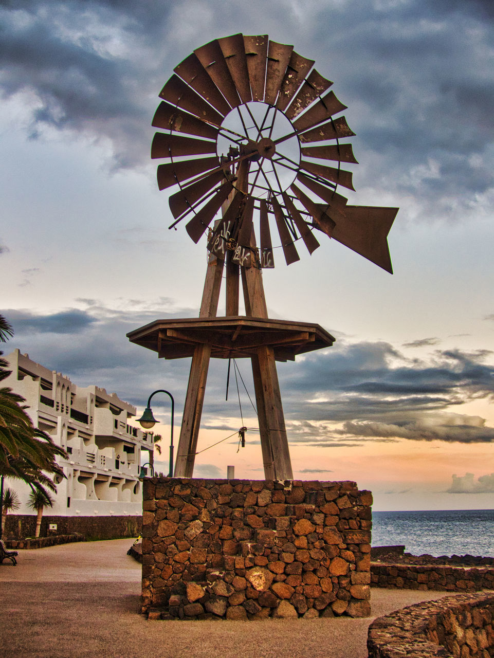 TRADITIONAL WINDMILL BY SEA AGAINST SKY