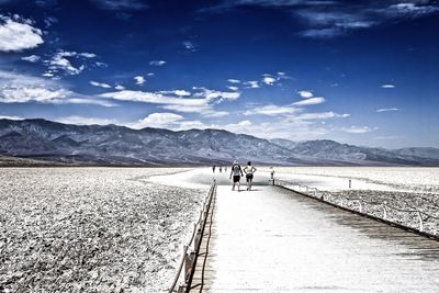 People on snowcapped mountains against sky