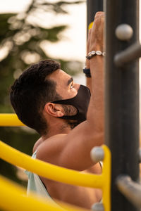 Side view of young man exercising outdoors
