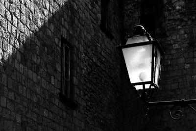 Low angle view of lamp against old building