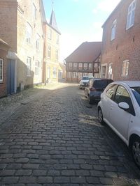 Cobblestone street amidst buildings in city