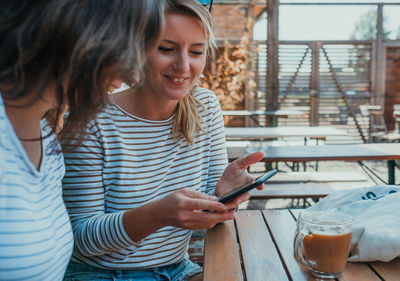 Young woman using smart phone on table