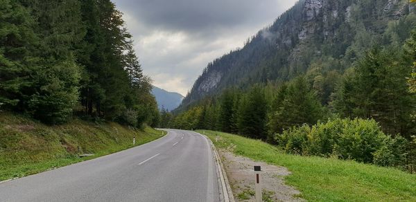 Road amidst trees against sky