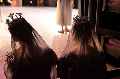 Rear view of women standing in corridor