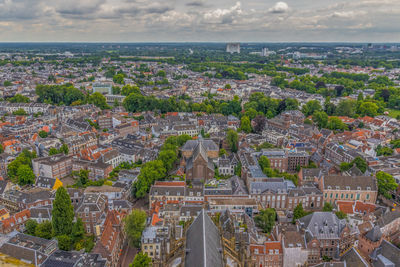 High angle view of city buildings against cloudy sky