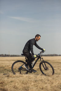 Young man riding a bike on grass field