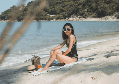 Beautiful woman in black swimsuit on the beach