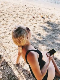 High angle view of woman using mobile phone at beach