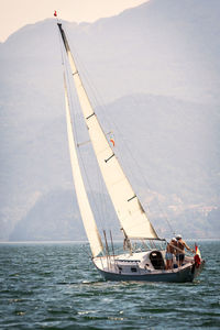 Sailboat sailing on sea against sky