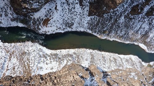 High angle view of river amidst rock formations during winter