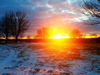 Scenic view of snow covered landscape at sunset