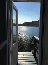 View of sea against sky seen through window