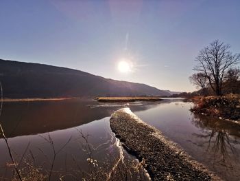 Scenic view of lake against bright sun