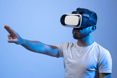 Rear view of man with camera against blue background