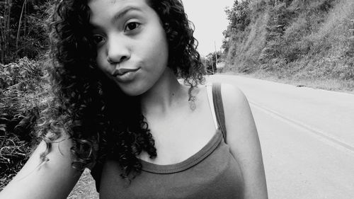 Close-up of young woman looking away while puckering at roadside