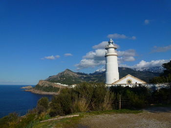 Lighthouse by sea against sky porto soller, majorca